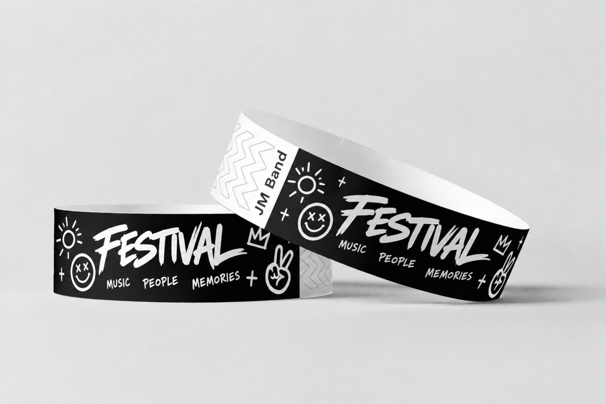 Kaksi mustaa paperiranneketta, joissa valkoinen festivaalipainatus