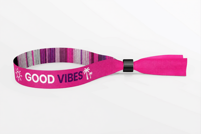 Vaaleanpunainen kudottu kangasranneke, jossa kudottu Good Vibes -teksti